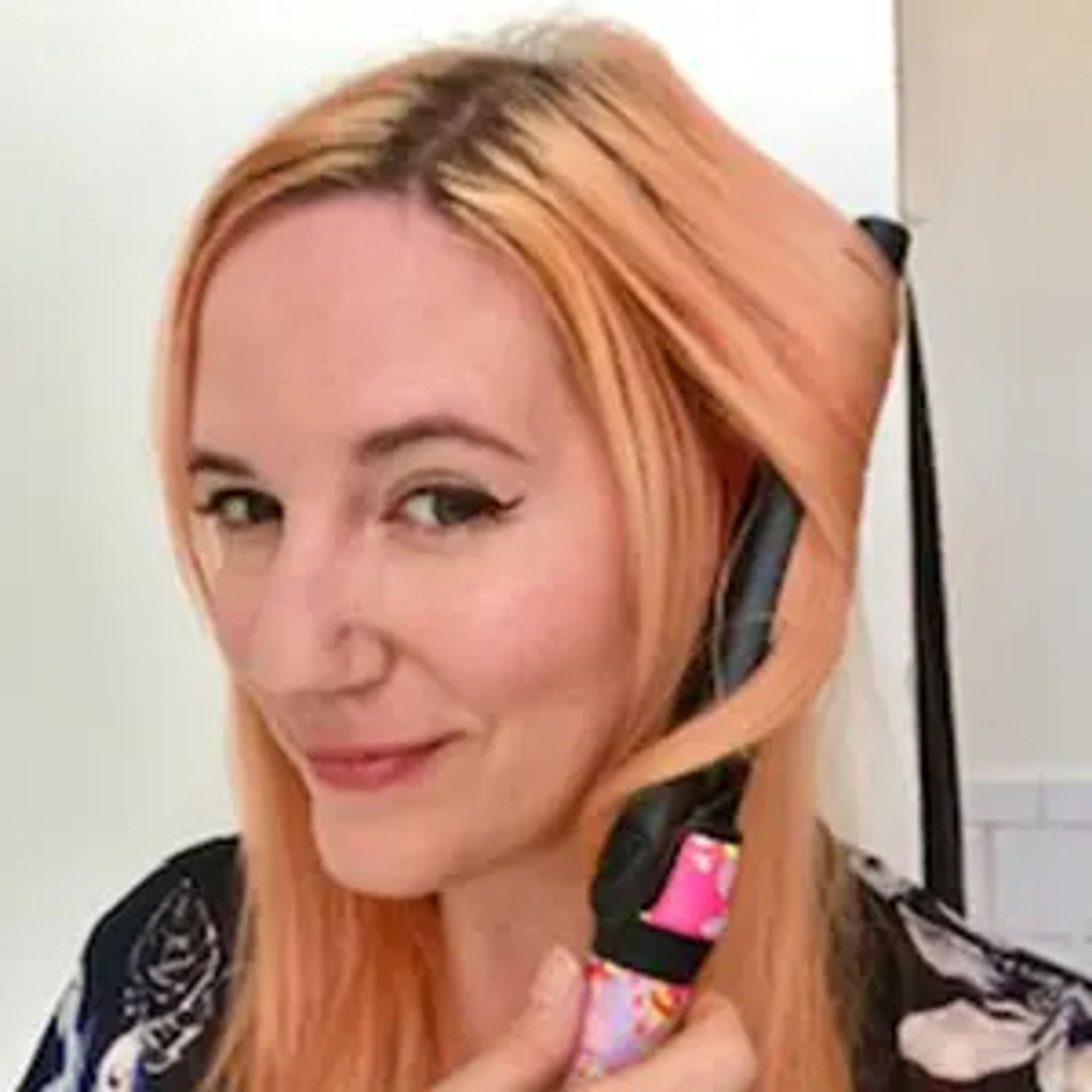 person styling hair with curling wand