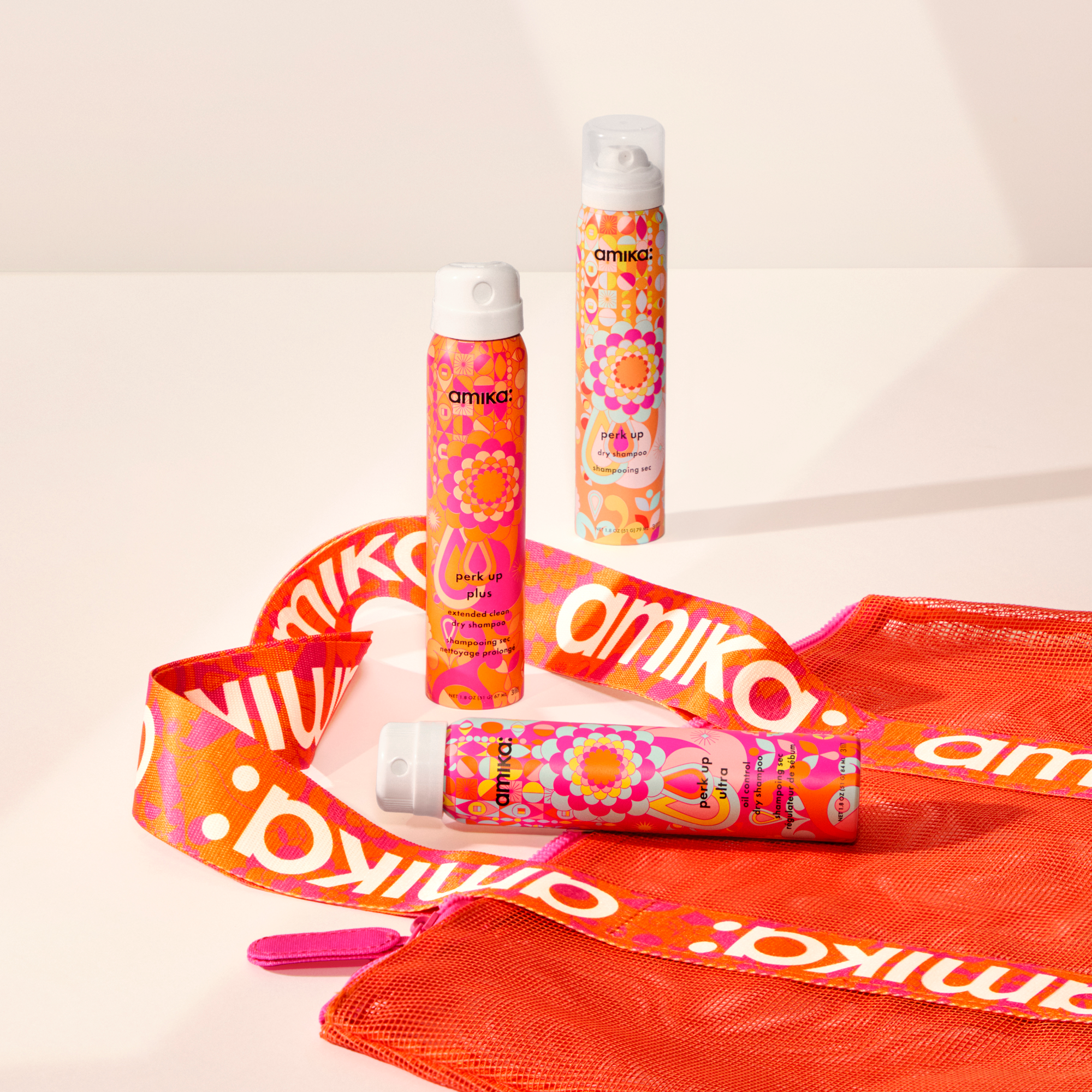 amika limited time gift with purchase: 3 travel sized dry shampoos: perk up, perk up ultra, and  perk up plus, along with a mesh beach tote bag with amika logo handles
