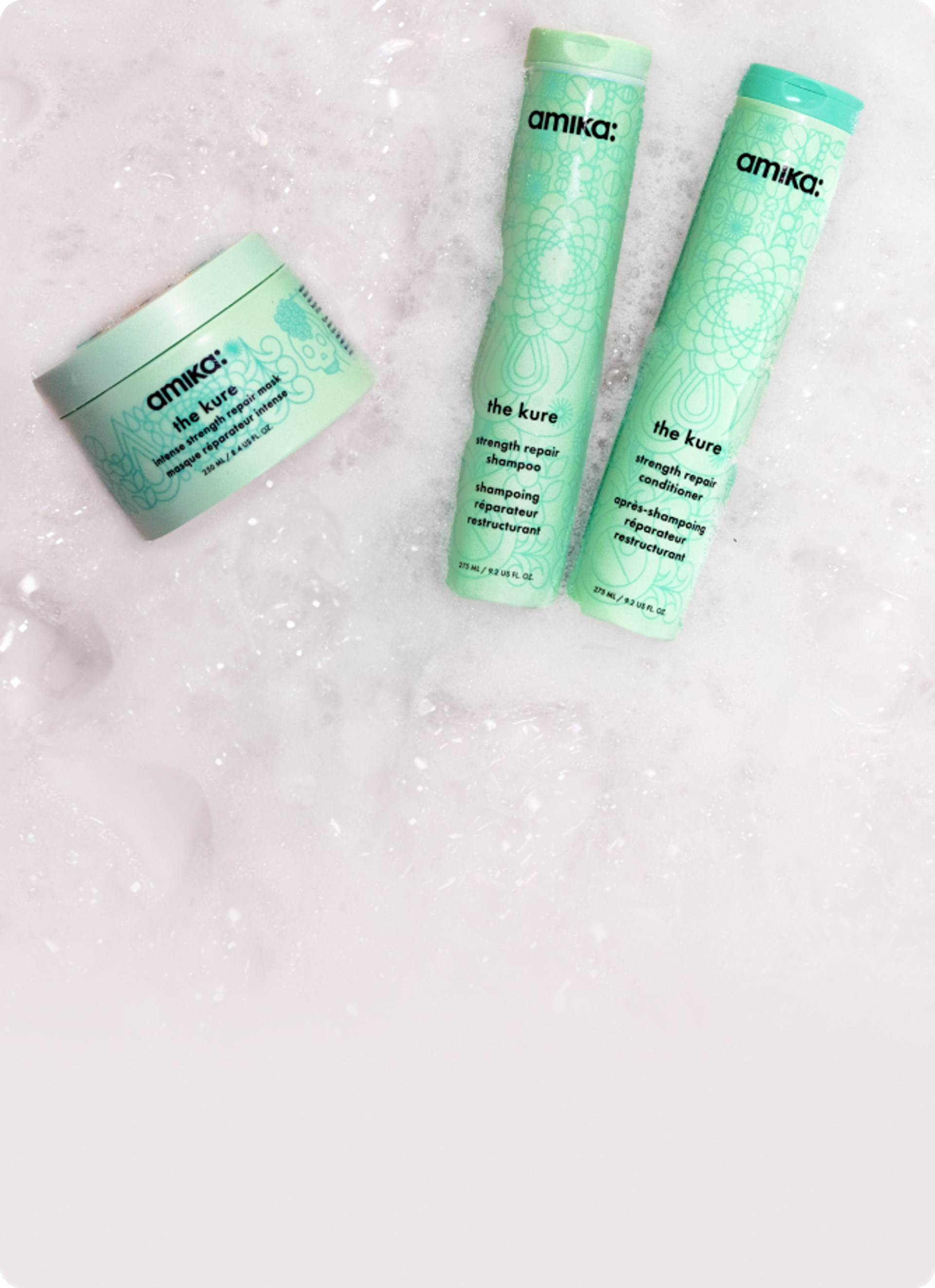 amika the kure shampoo, conditioner and intense mask sit amongst sudsy bubbles