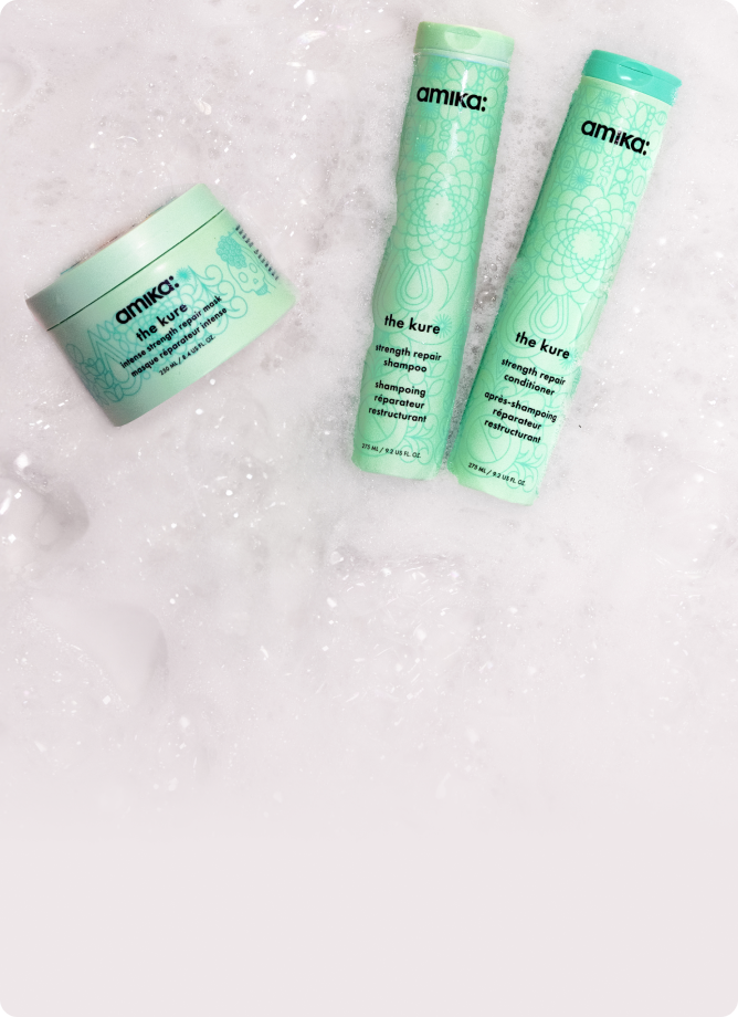 amika the kure shampoo, conditioner and intense mask sit amongst sudsy bubbles