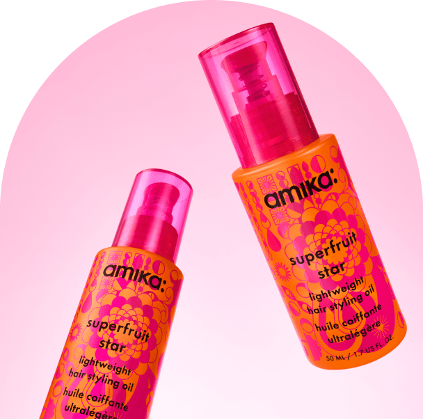 bottles of amika superfruit star float against a pink background