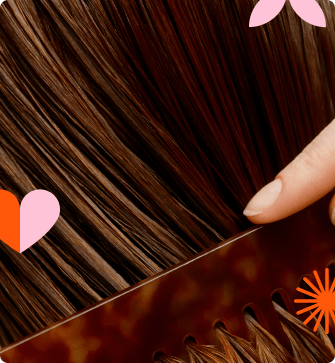 a person's hand runs a comb through brown hair