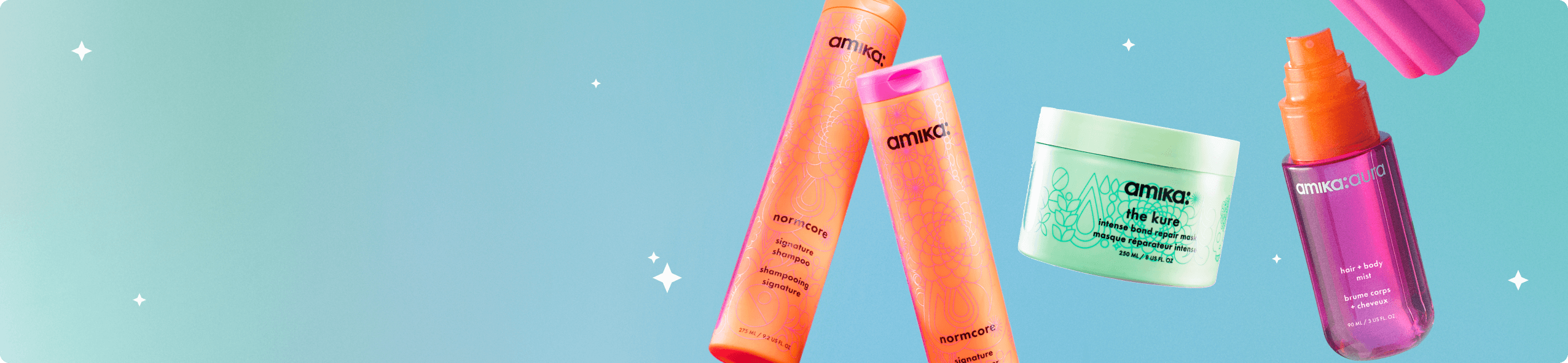 amika bottles of shampoo, mask, and hair + body fragrance mist float against a light blue background with tiny white sparkles