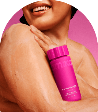 a model with lather on their skin holds amika shower thoughts against their chest. there is a pink background