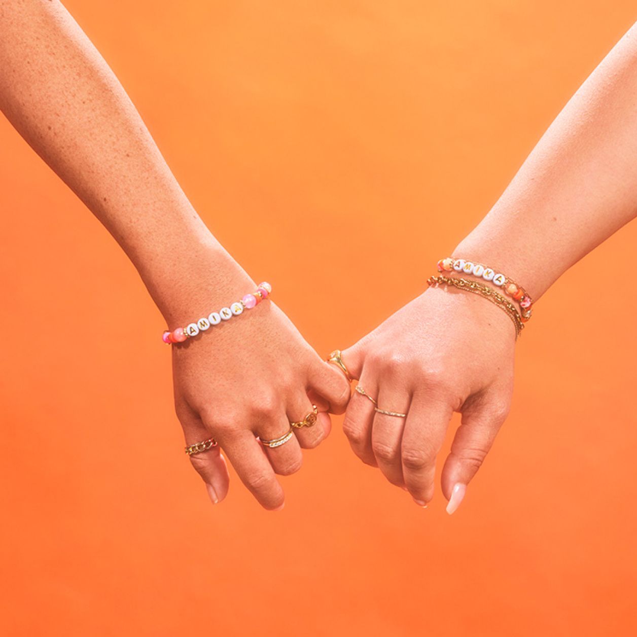 two models holding hands with amika bracelets.