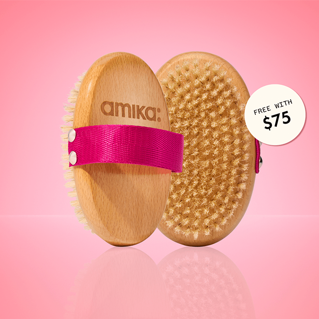 a dry body brush shown front and back stands against a pink background. a sticker reads: "free with $75" (orders)