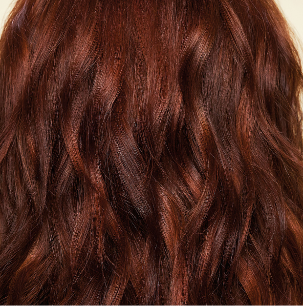 back of a model's smooth, shiny, red, wavy hair