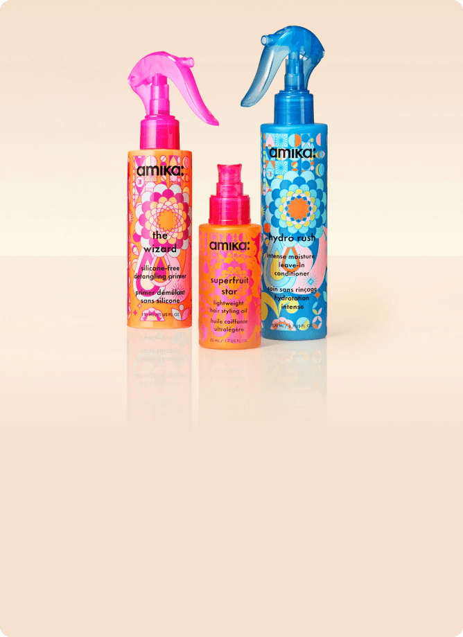 amika treatments: the wizard silicone-free primer, superfruit star oil, and hydro rush leave-in conditioner against a cream background