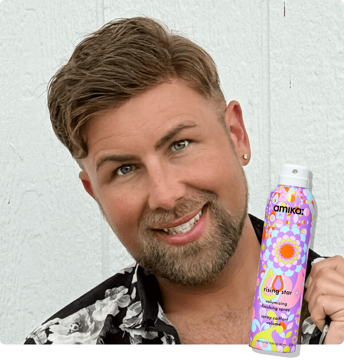 amika Brand Educator Derek Viers poses smiling. A sticker of amika rising star finishing spray appears in the bottom right corner.