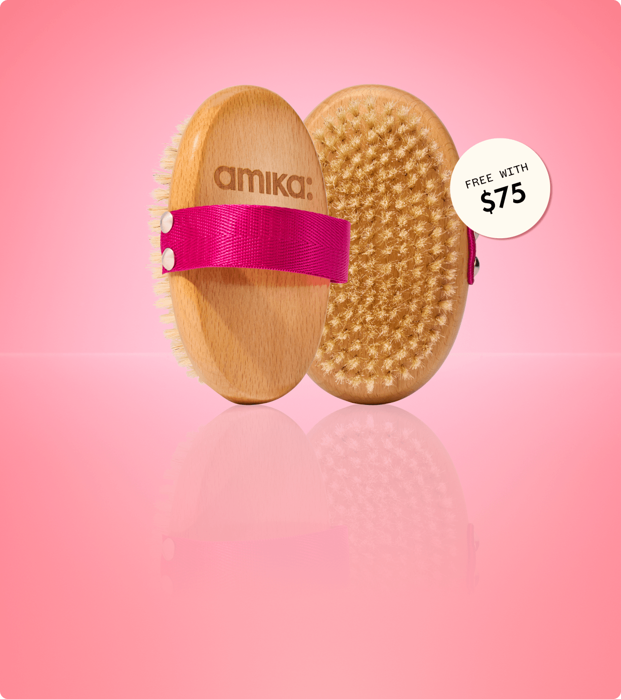 a dry body brush shown front and back stands against a pink background. a sticker reads: "free with $75" (orders)