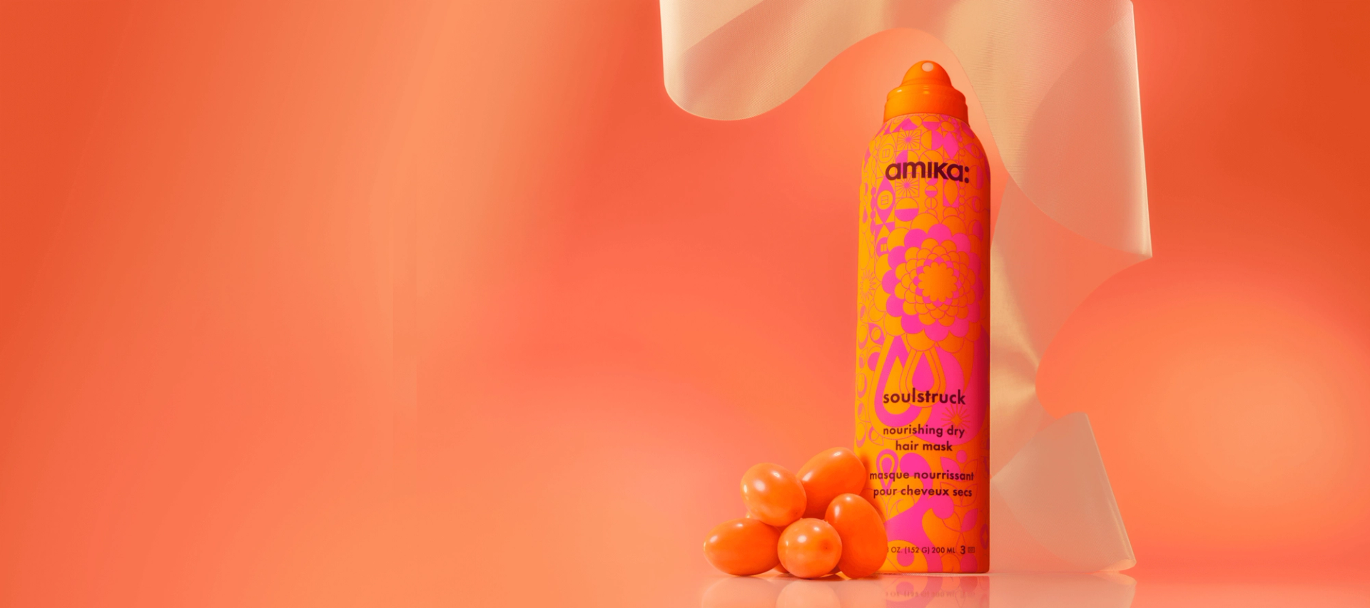 amika soulstruck spray and sea buckthorn berries in front of a amika products in front of a orange gradient background
