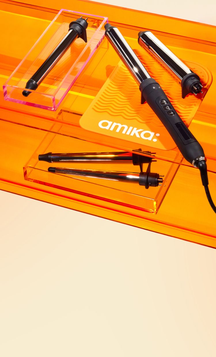 amika's chameleon curling iron on an orange table