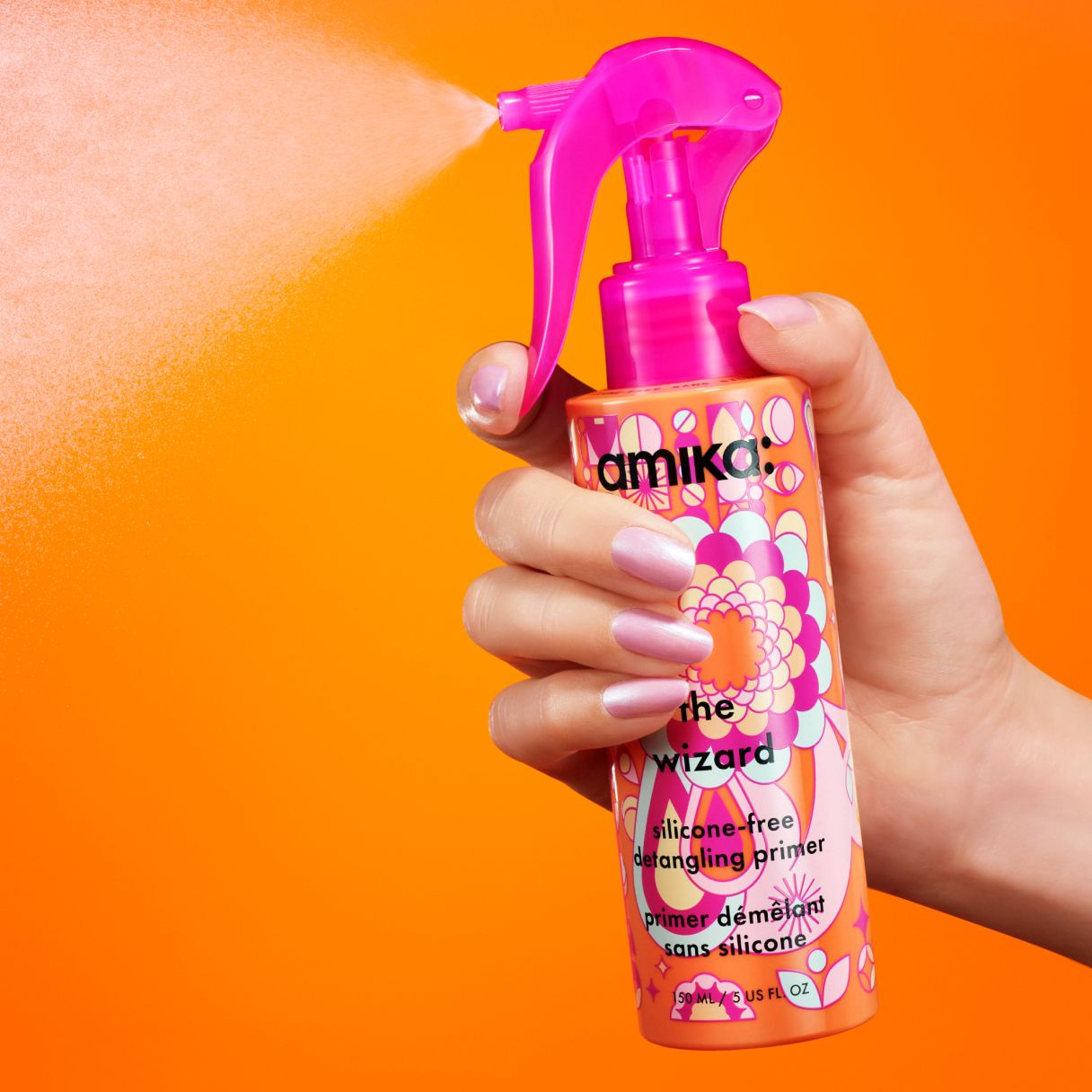 the wizard silicone-free detangling primer spraying in front of an orange background