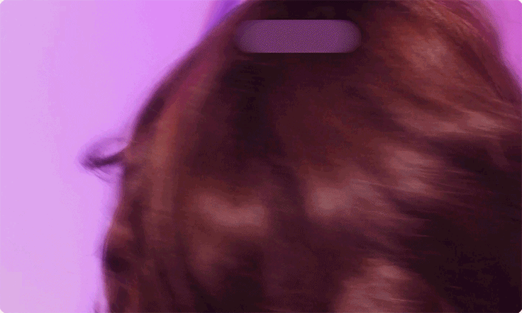 GIF (moving image) of a model spinning around with brown shiny, wavy hair