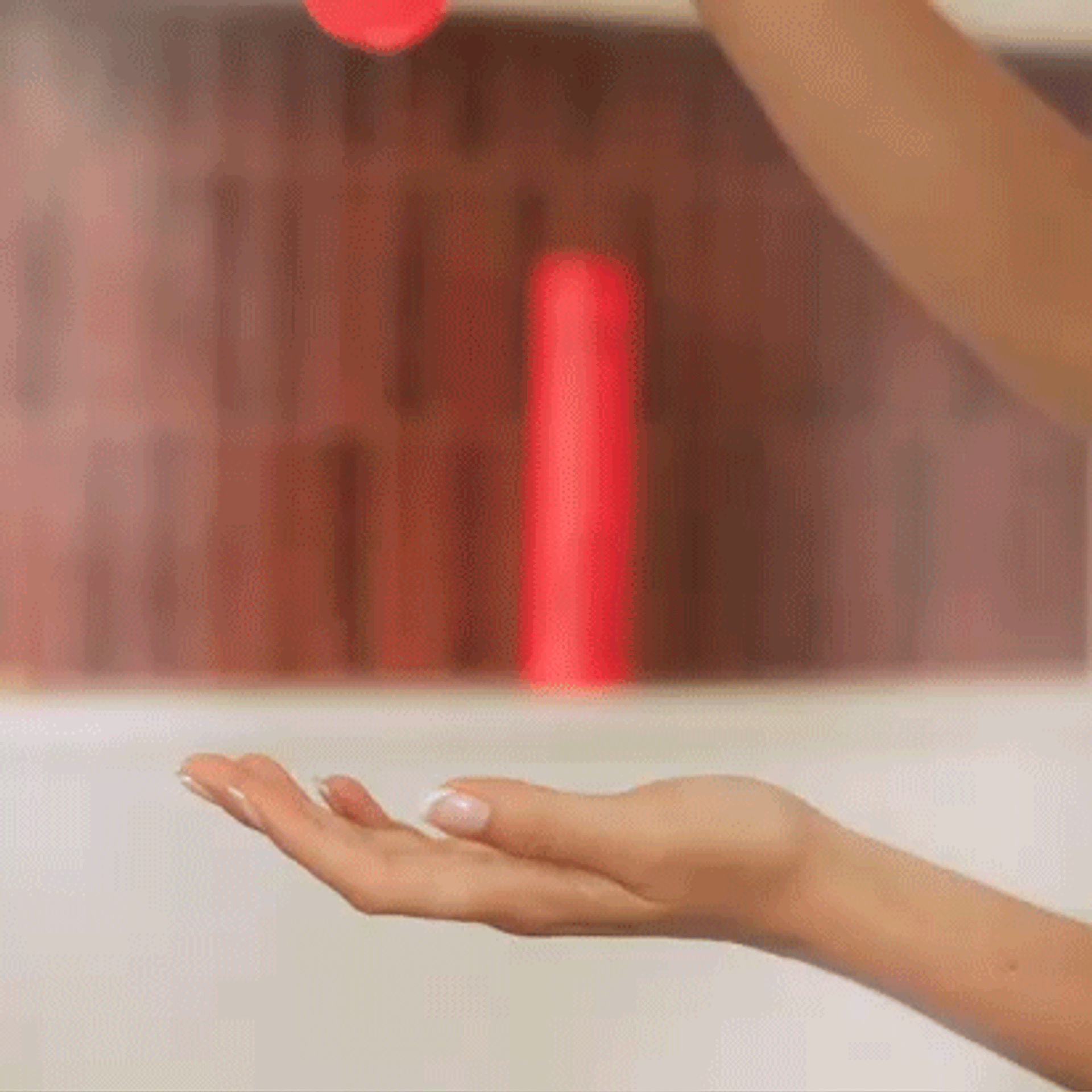 gif of a hand pouring amika protector shampoo into another hand with a shower in the background