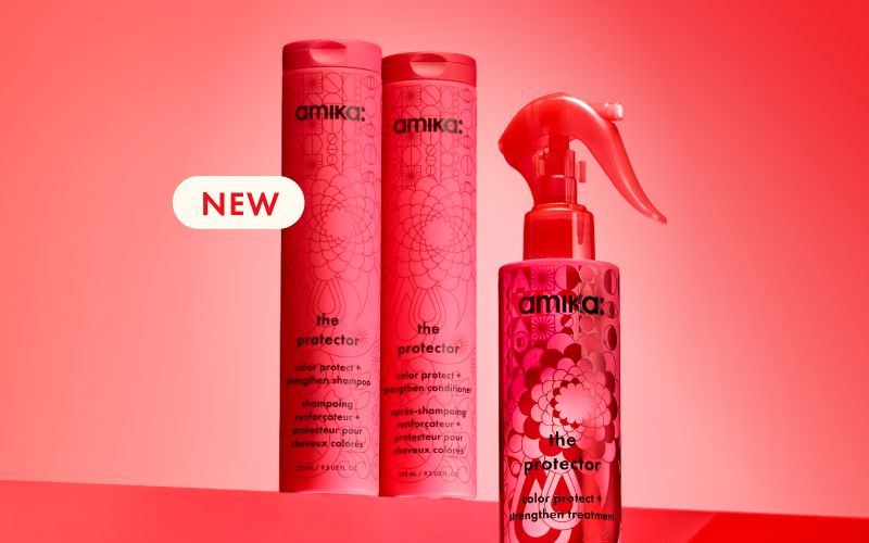 bottles of amika's the protector shampoo, conditioner, and treatment sit against a red gradient background