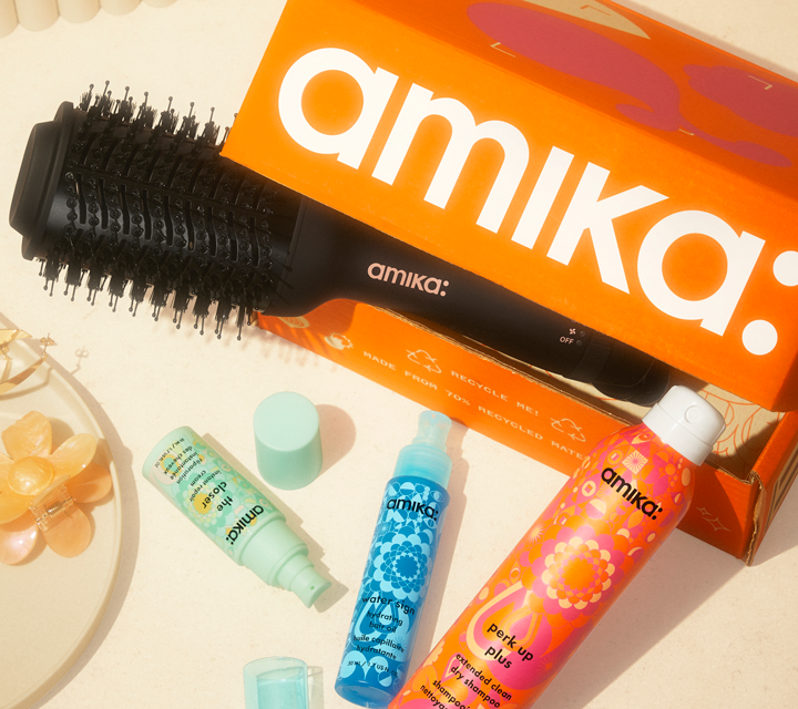 amika mailer box shown with hair blow dryer brush and product assortment on cream counter top