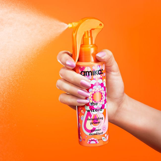 the wizard detangling primer spraying with an orange background
