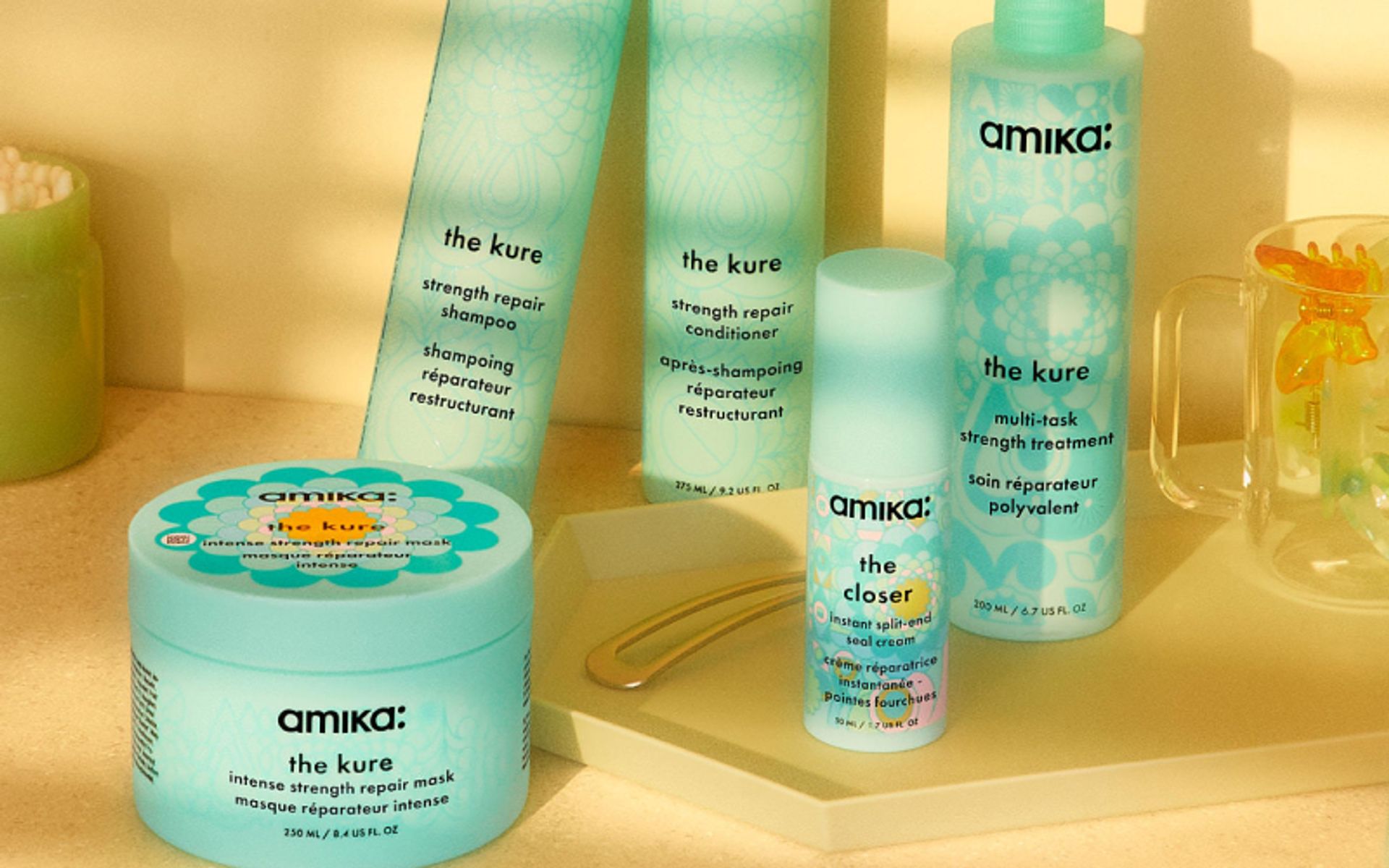 amika's the kure strength repair collection sits on a yellow countertop