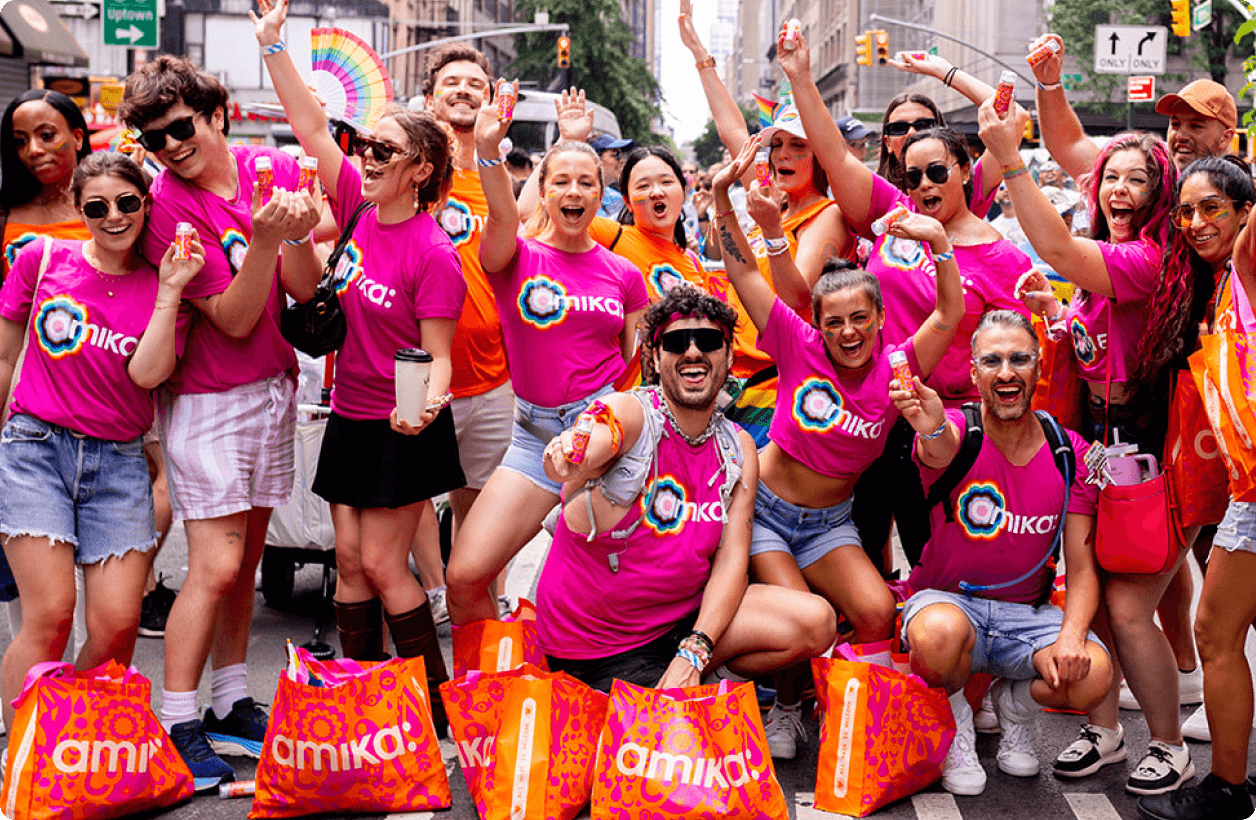 amika employees wearing pink amika t-shirts smiling and having fun at a Pride event
