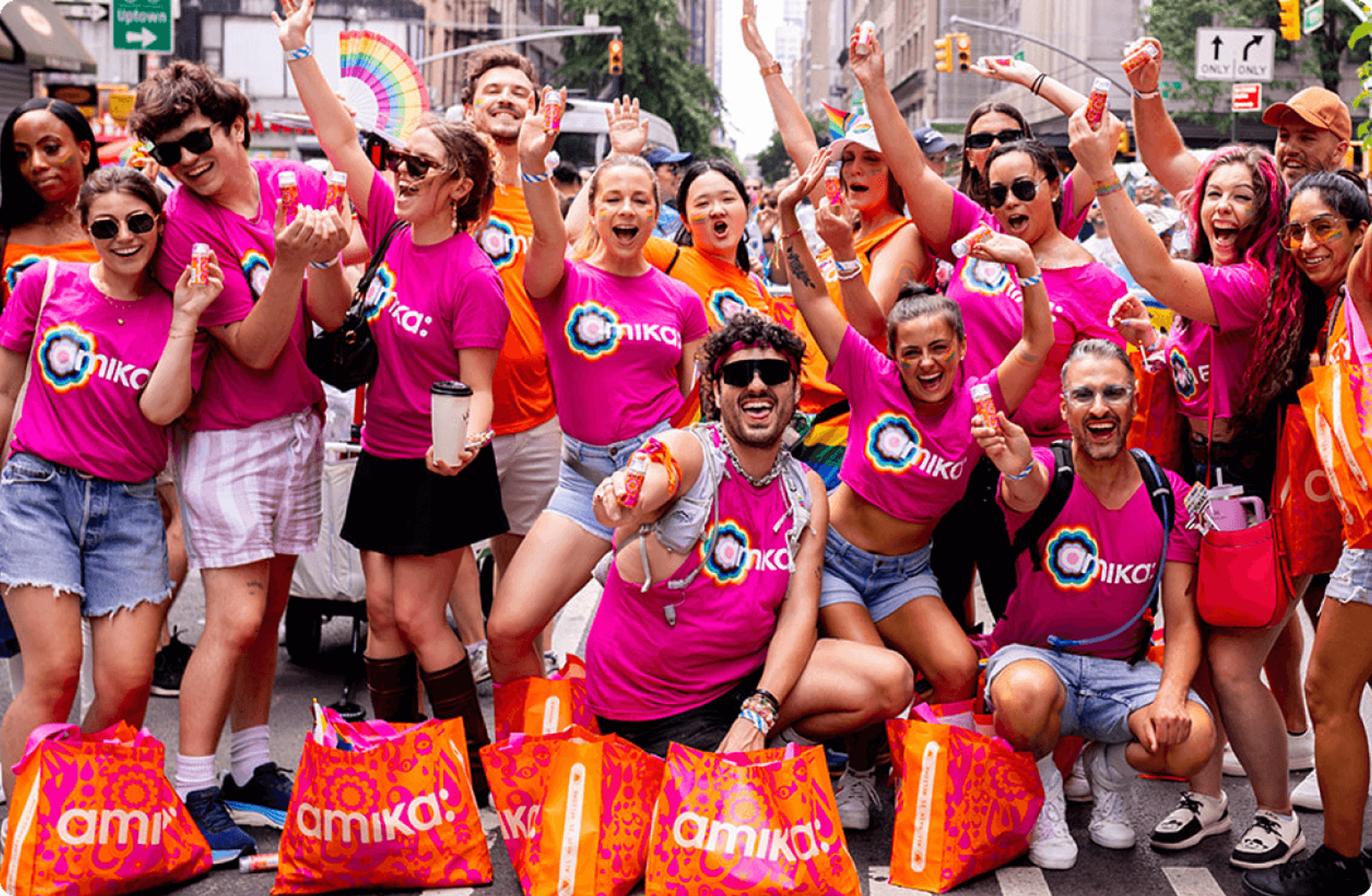 amika employees wearing pink amika t-shirts smiling and having fun at a Pride event