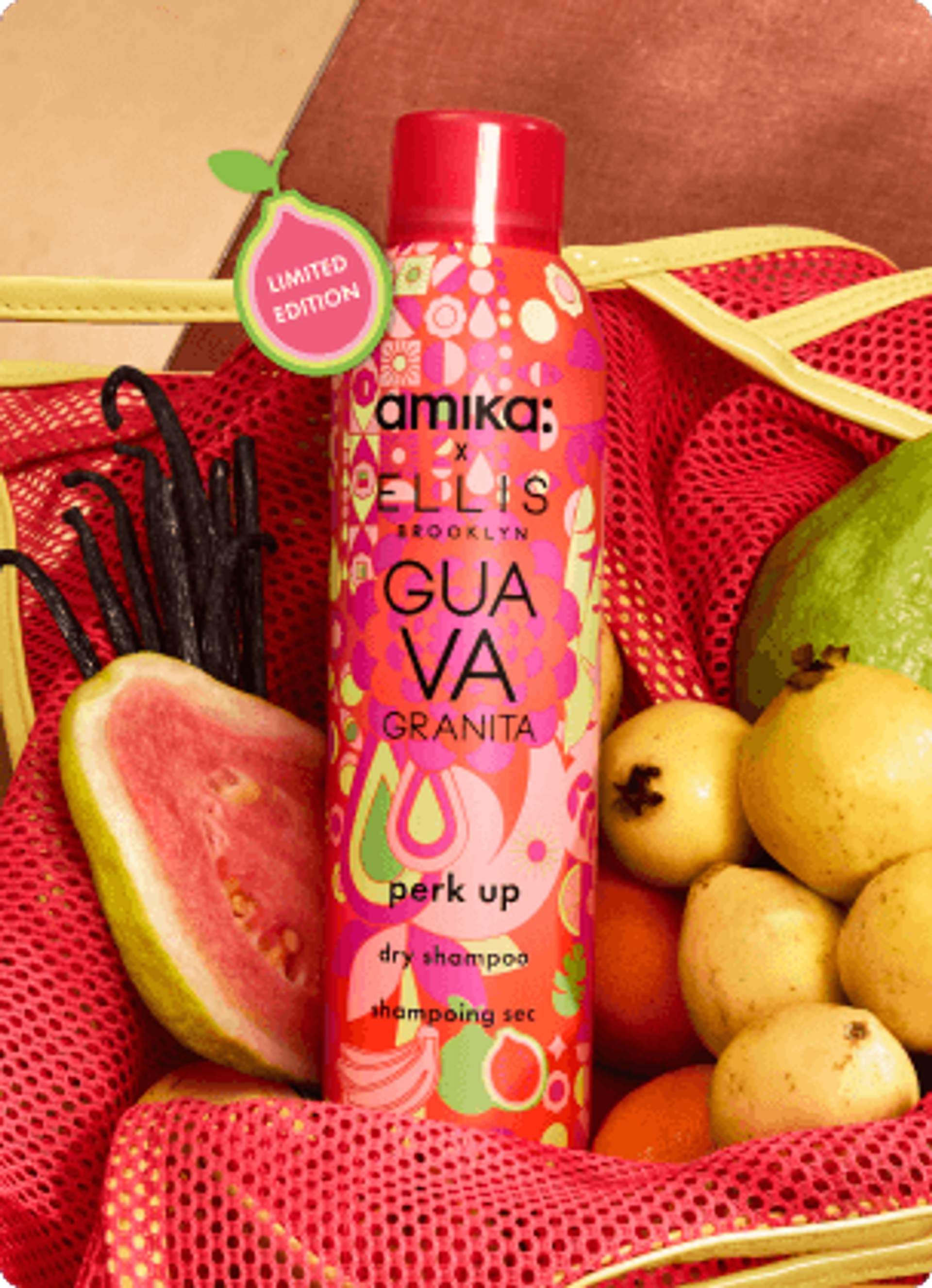 amika x Ellis Brooklyn limited-edition Guava Granita dry shampoo bottle in a mesh bag with fruit arranged around it