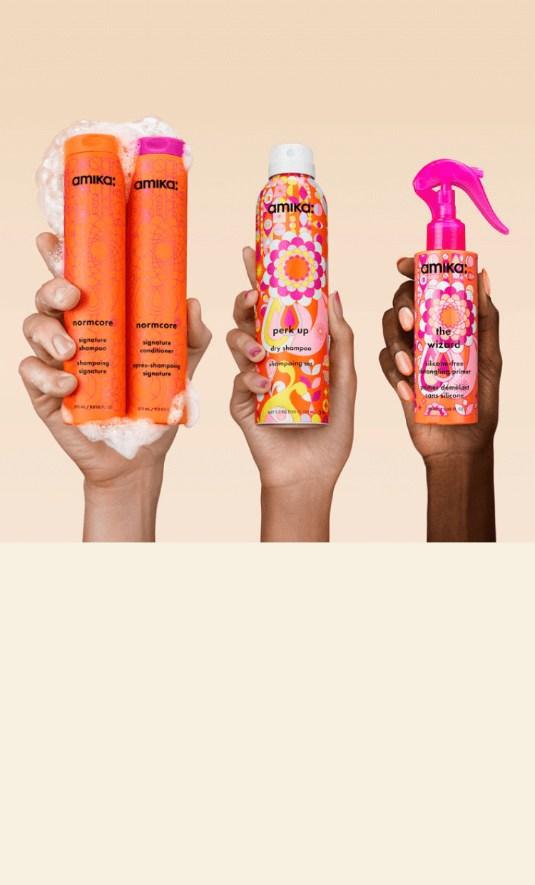 three hands hold up amika products against a cream background