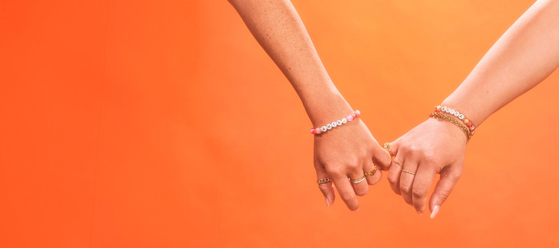 two models with pinky fingers intertwined