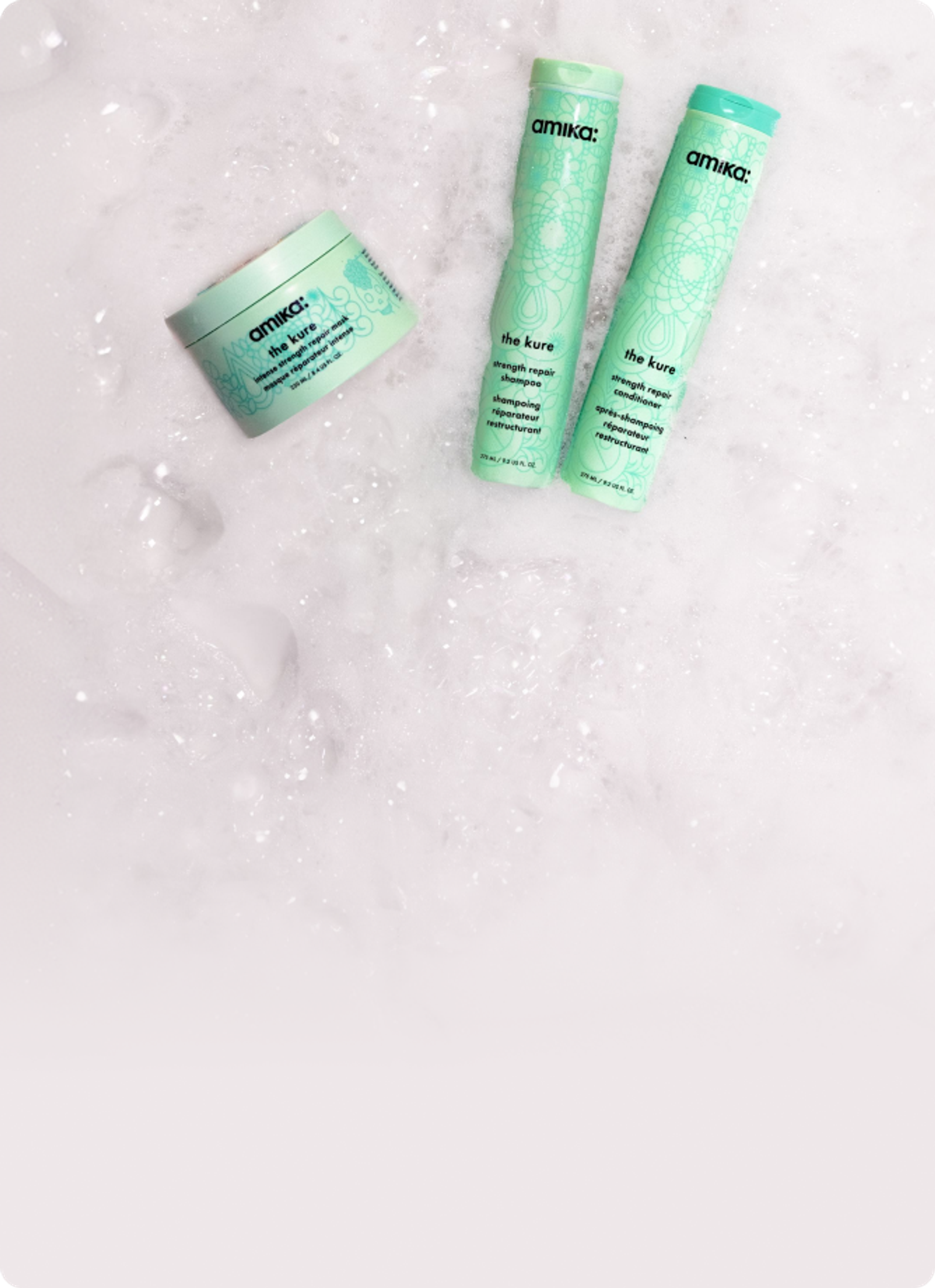 amika the kure shampoo, conditioner and intense mask sit amongst sudsy bubbles