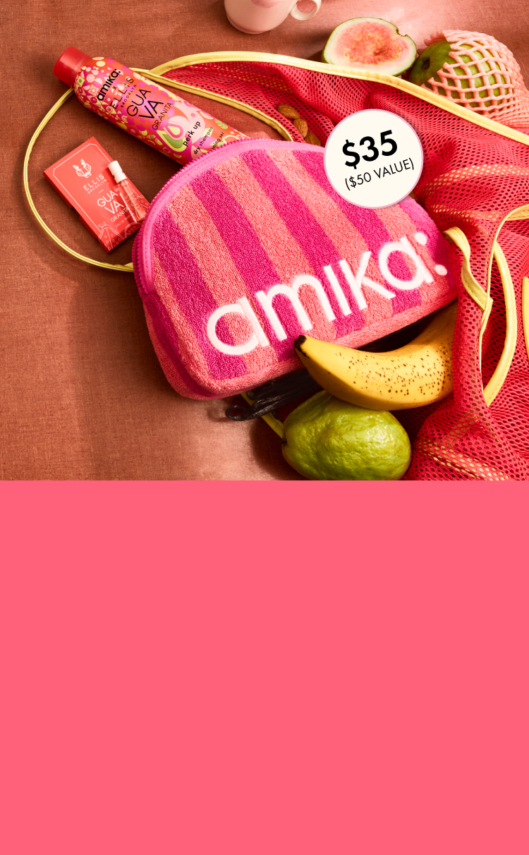 amika perk up GUAVA GRANITA, GUAVA GRANITA perfume sample, and pink striped logo terrycloth pouch lay amongst tropical fruits against a brown background
