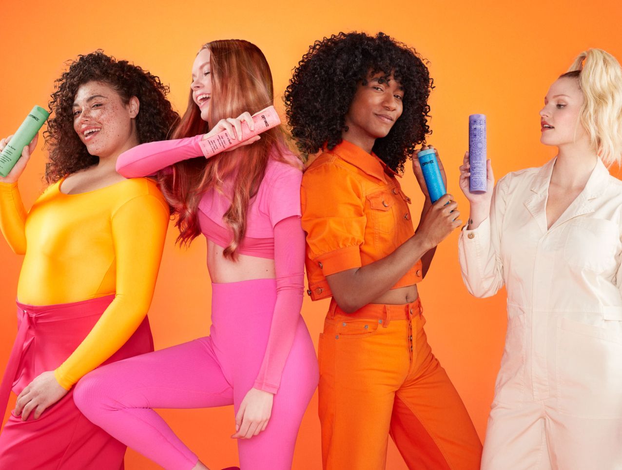 group of models posing with different amika shampoo bottles