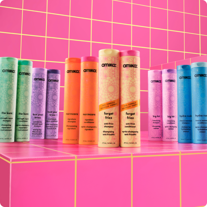 Image of amika's evergreen wash care duos. from left to right: kure strength repair shampoo and conditioner, bust your brass shampoo and conditioner, normcore shampoo and conditioner, forget frizz shampoo and conditioner, hydro rush shampoo and conditioner, and big hit shampoo and conditioner.