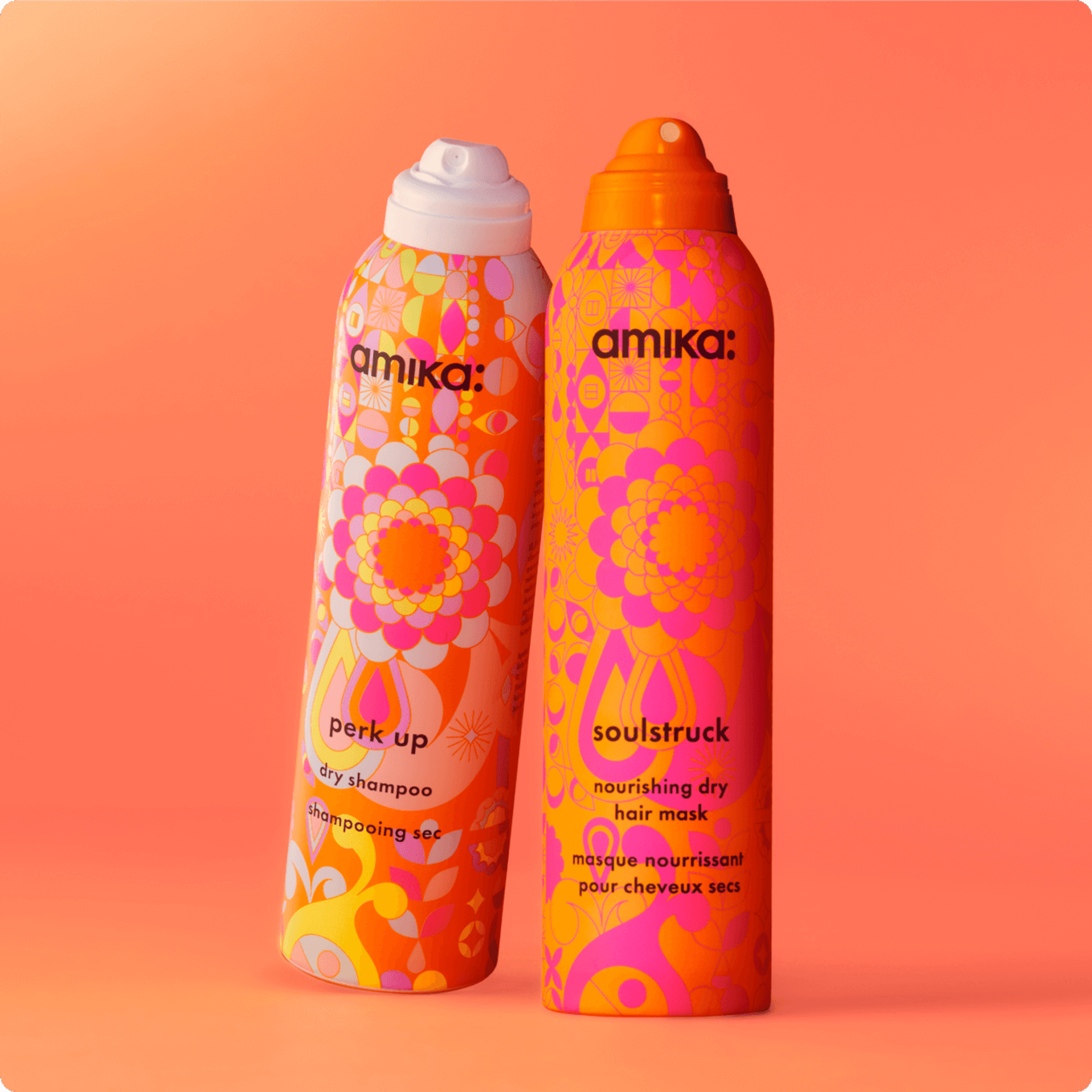 bottles of amika soulstruck and perk up stand against an orange background