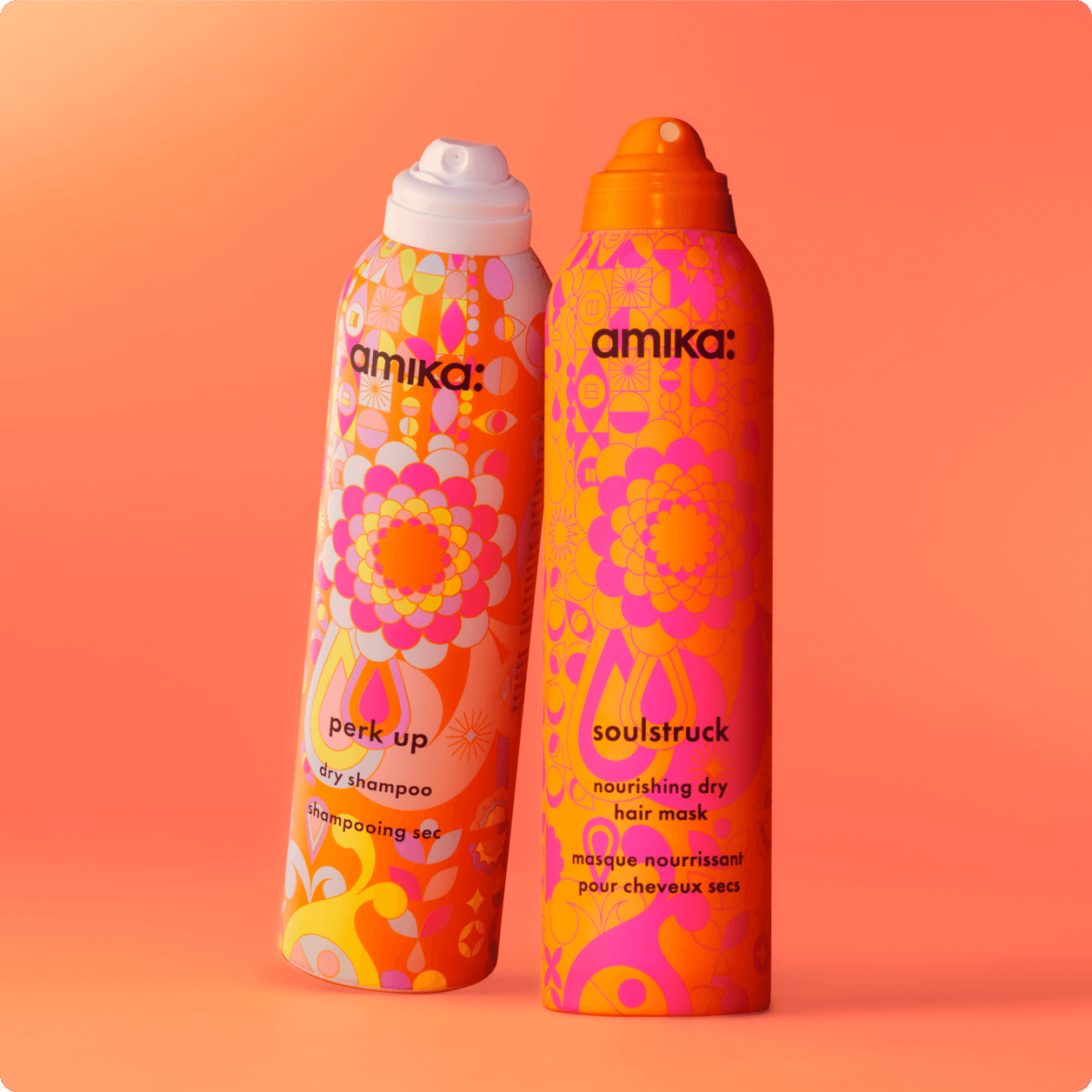 bottles of amika soulstruck and perk up stand against an orange background