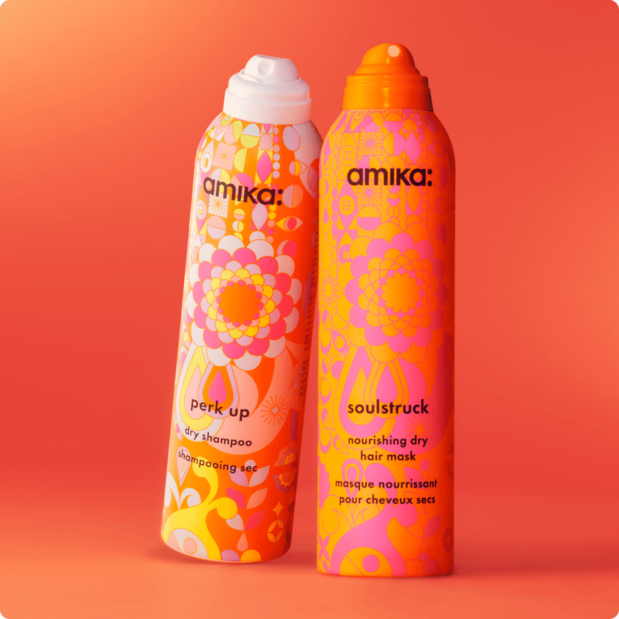bottles of amika soulstruck and perk up stand against an orange background