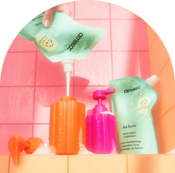 image of amika refill bundle, the kure refill pouches and one pink and one orange refillable bottles sit against a pink and orange tiled background.
