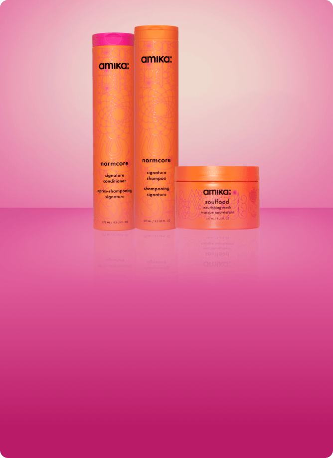 amika normcore shampoo and conditioner and soulfood mask sit against a pink gradient background