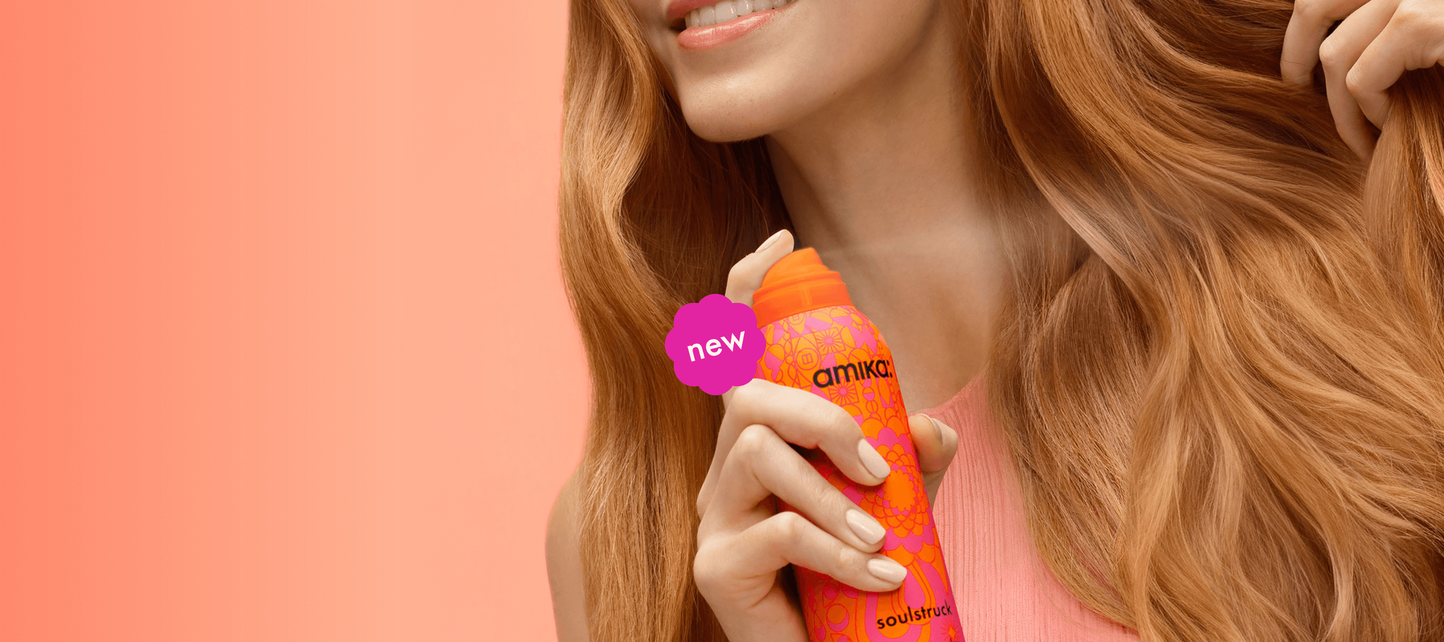 closeup image of a person spraying amika soulstruck mask on their wavy, red hair