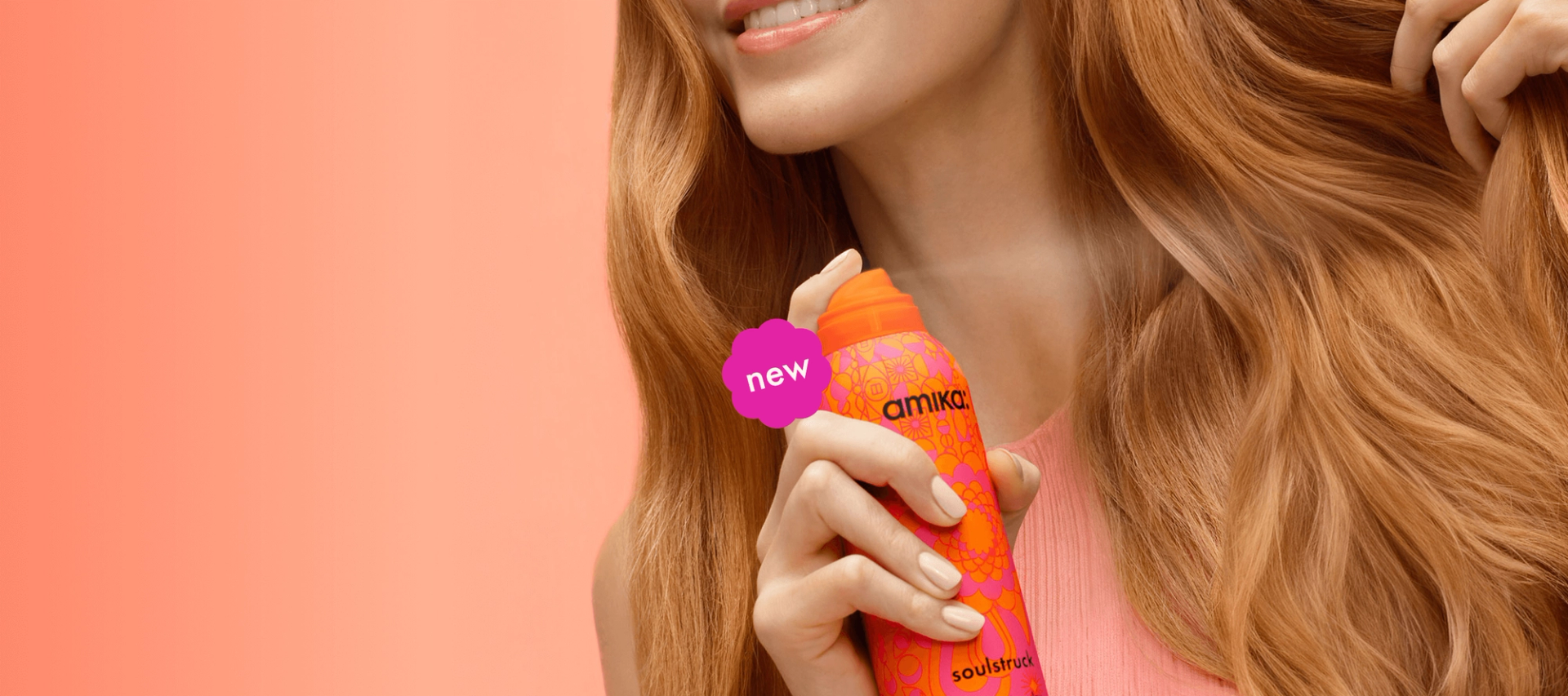 closeup image of a person spraying amika soulstruck mask on their wavy, red hair