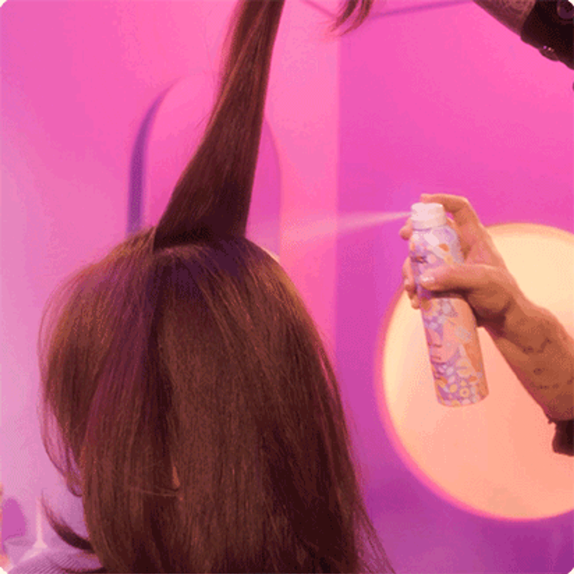 animated gif showing rising star spray spraying into models hair in front of a purple background