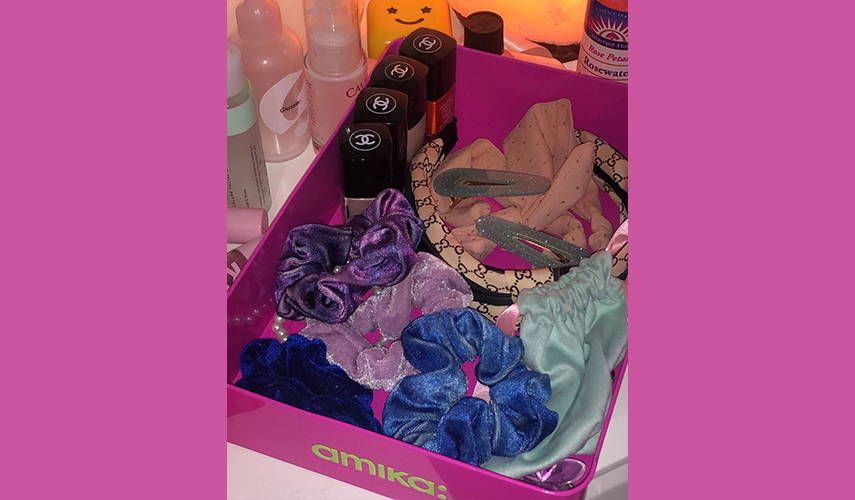 empty amika box reused to hold hair accessories and makeup