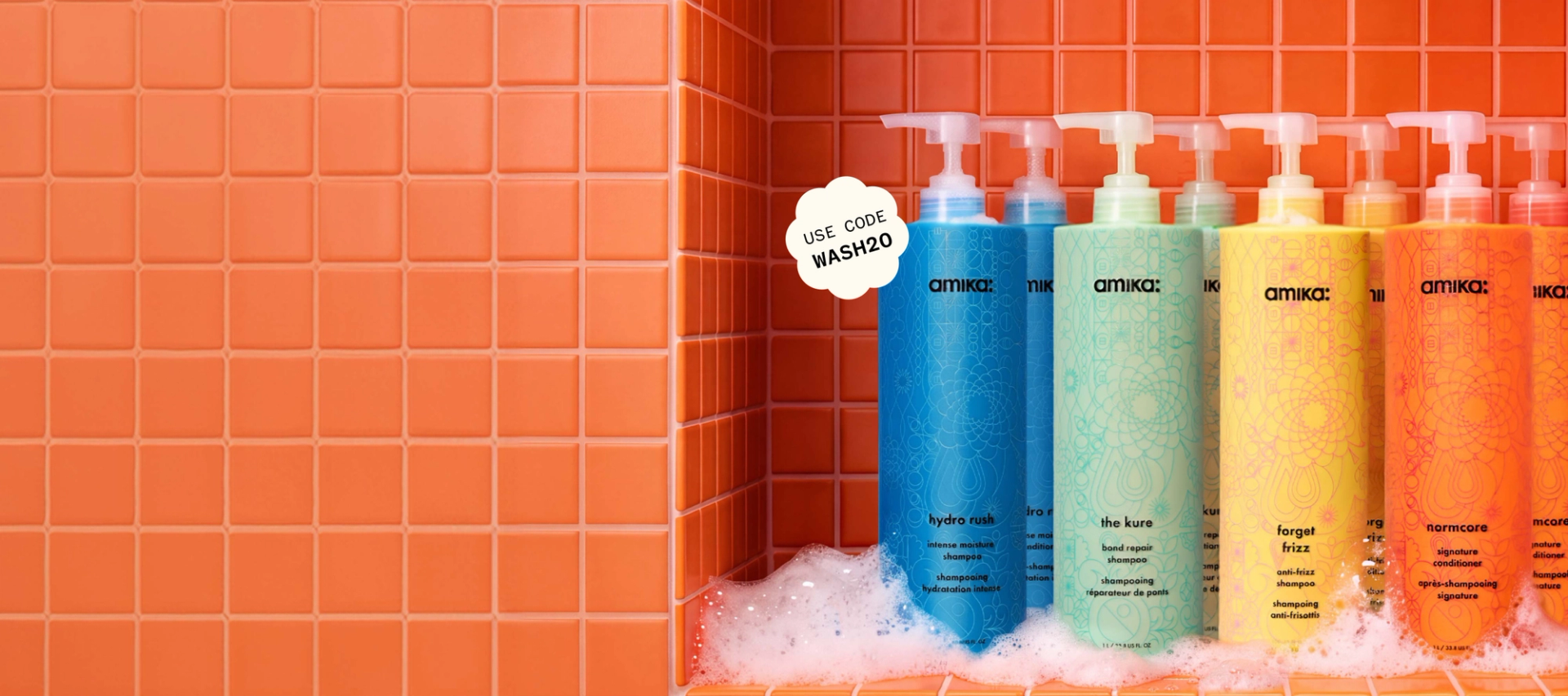 amika bottles of shampoo and conditioner against an orange tiled background with some suds at the bottom of the surface. a sticker reads: "20% OFF with code WASH20"