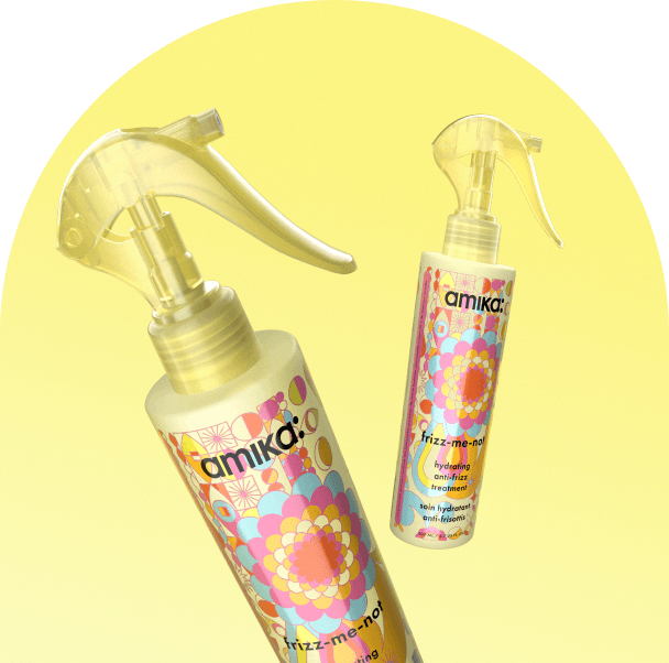 bottles of amika frizz-me-not float against a yellow background