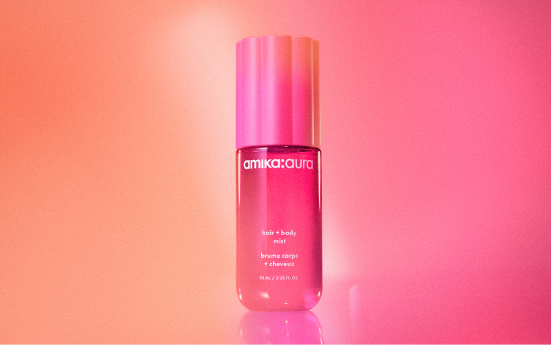 amika:aura hair and body mist sits against a pink and orange background
