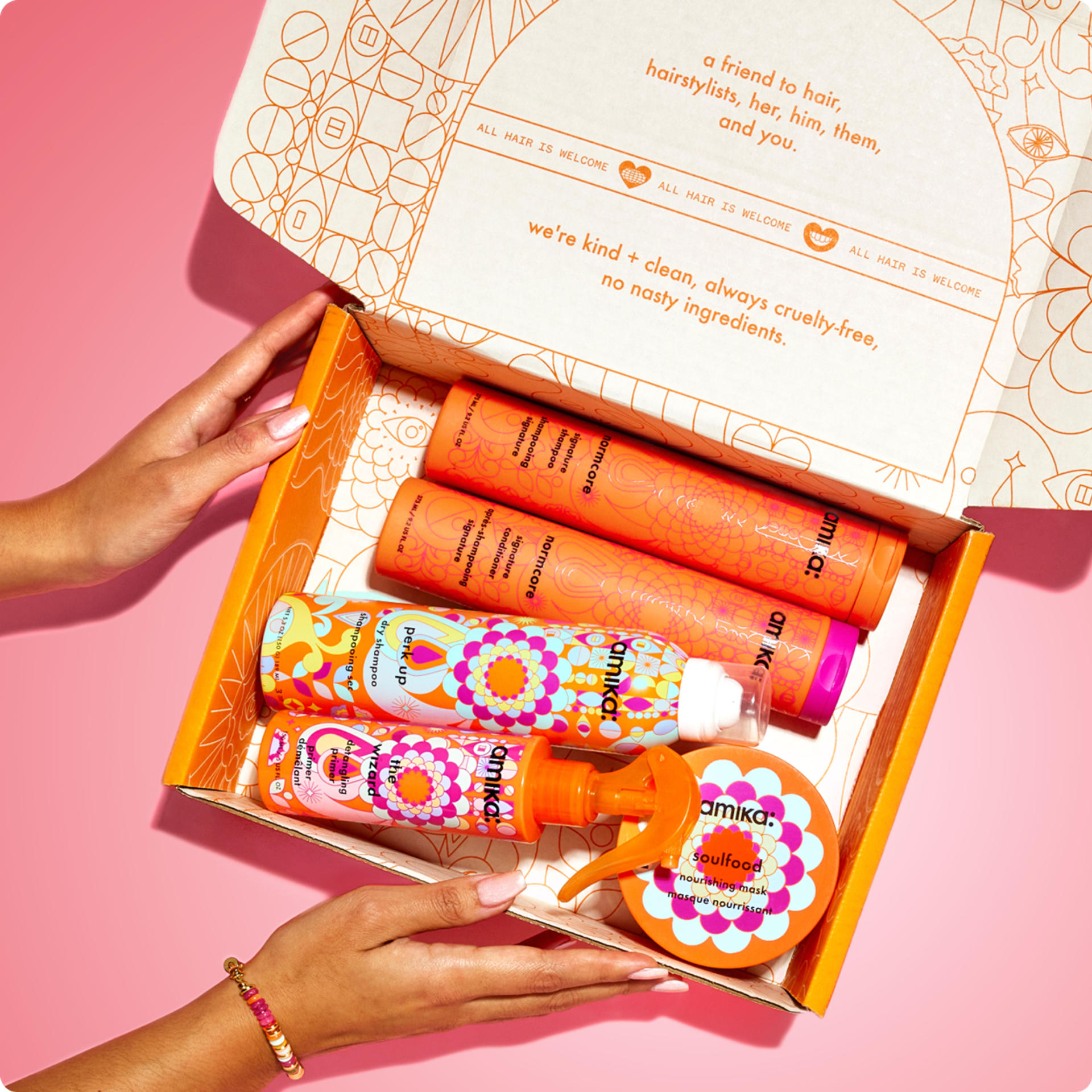 an amika mailer box with signature amika products including normcore shampoo and conditioner, perk up dry shampoo and wizard detangling primer and soulfood nourishing mask