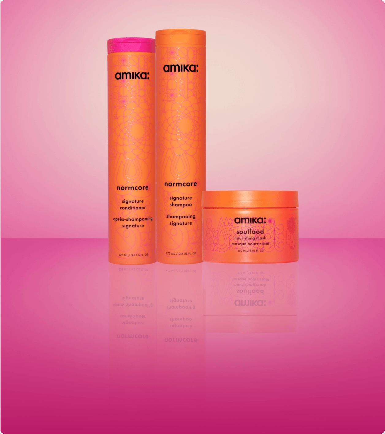 amika normcore shampoo and conditioner and soulfood mask sit against a pink gradient background