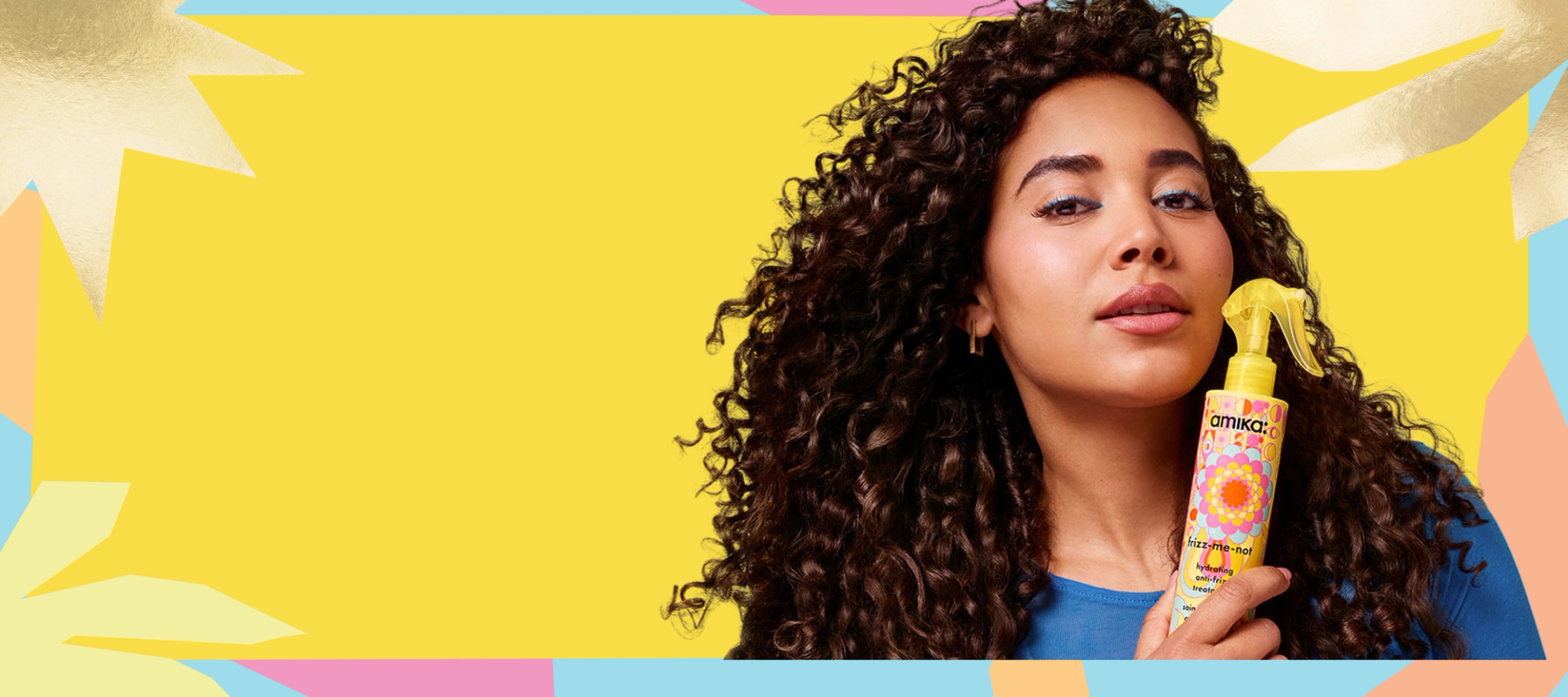 a model holds a bottle of amika frizz-me-not treatment against a yellow background with a pastel and gold patterned border