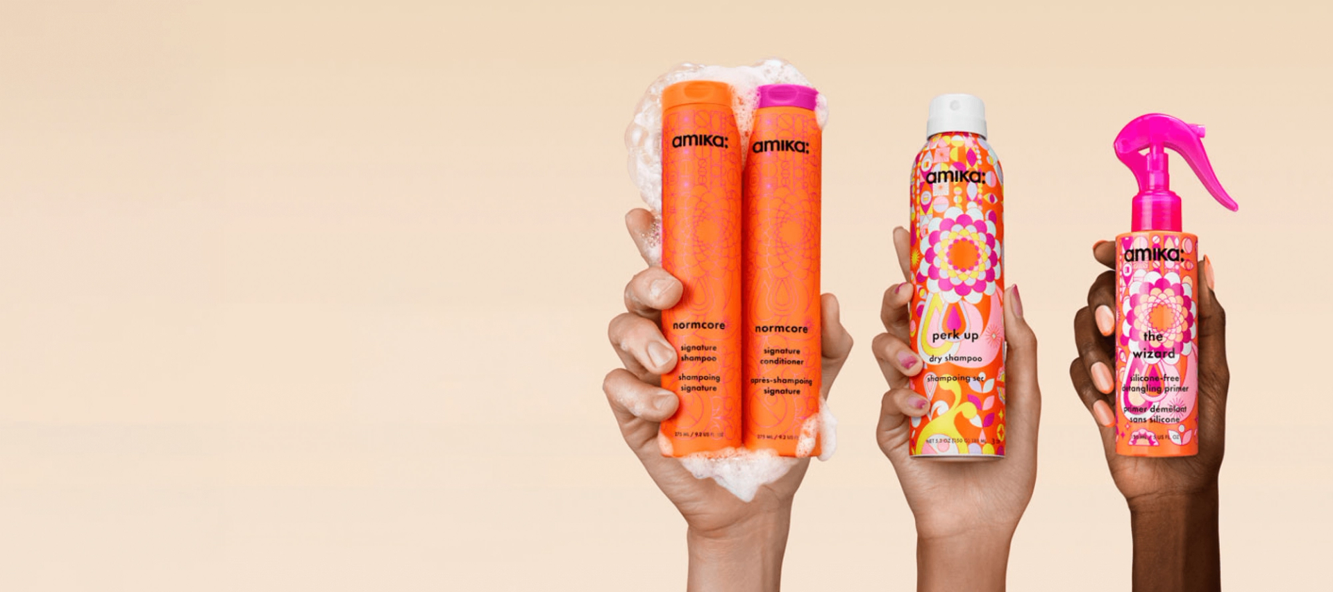 three hands hold up amika products against a cream background