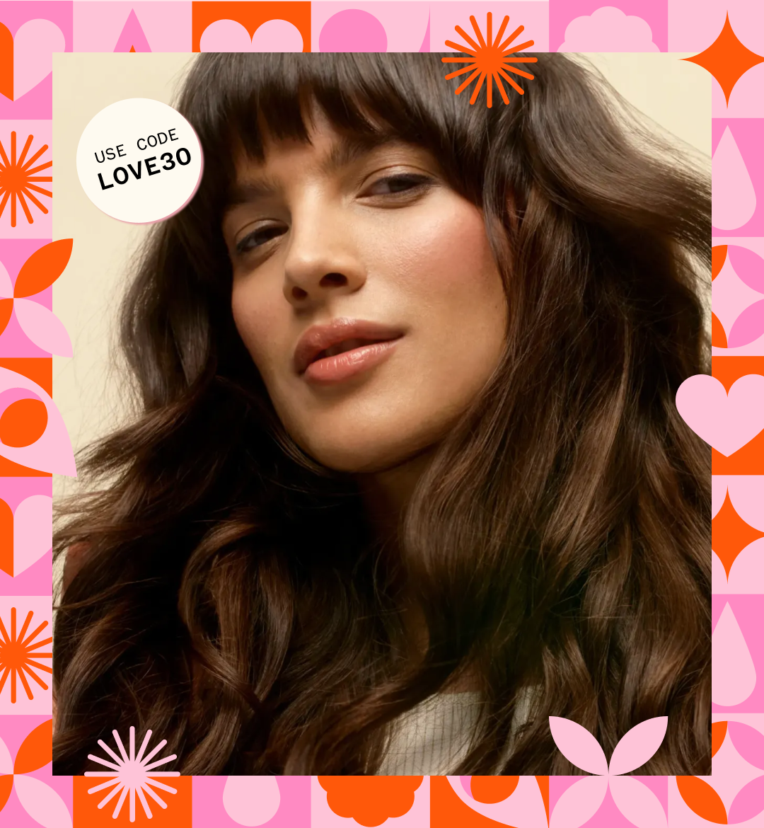 a model with brown, wavy hair stands in front of a cream background. a pink and orange pattern creates a border. stickers read "use code LOVE30"