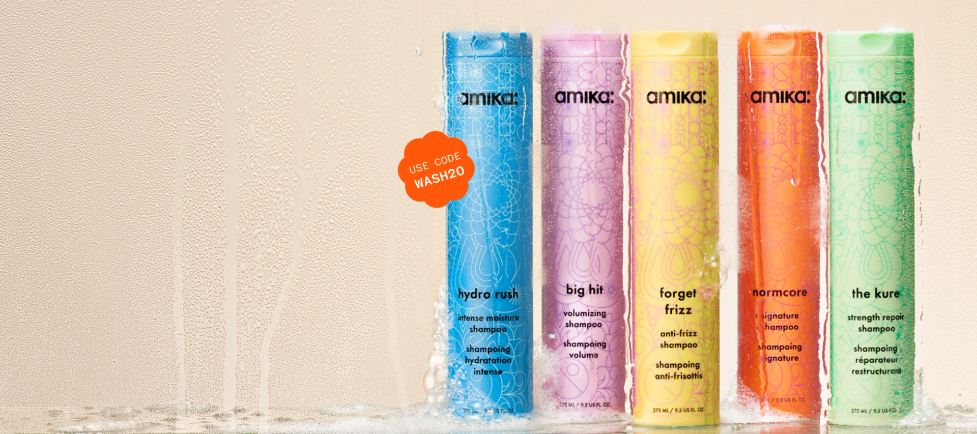 amika bottles of shampoo and conditioner in a steamy shower setting with some suds at the bottom of the surface. a sticker reads: "use code WASH20"